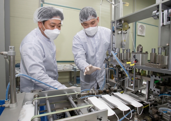 대전에 위치한 마스크 제조기업 '레스텍'의 박나원 공장장(오른쪽)과 삼성전자 스마트공장지원센터 권오창 멘토(왼쪽)가 마스크 상태를 점검하고 있다. 사진. 삼성전자.