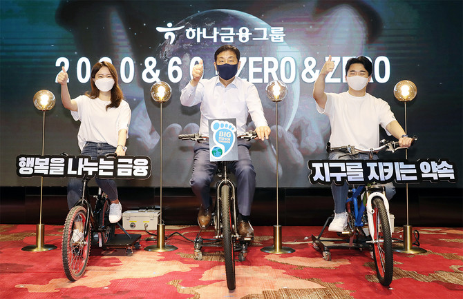 김정태 하나금융그룹 회장(가운데)과 참석자들이 친환경 자가발전 자전거 세리머니를 하고 있다. 사진. 하나금융그룹.