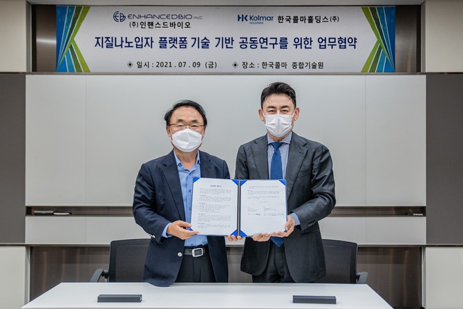 지난 9일 강학희 한국콜마 기술연구원 원장(왼쪽)과 김홍중 인핸스드바이오 대표가 서울 내곡동 소재 종합기술원에서 '지질나노입자 플랫폼 기술 기반 공동연구를 위한 업무 협약(MOU)'을 체결한 뒤 협약서를 들어보이고 있다. 사진. 한국콜마홀딩스