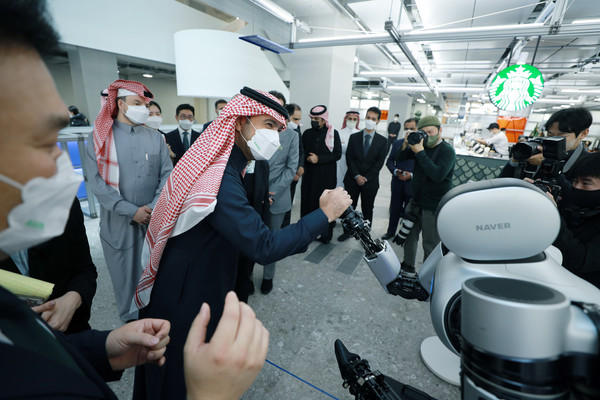 알 호가일 사우디아라비아 자치행정주택부 장관이 네이버1784에서 로봇팔 앰비덱스와 악수하고 있다. 사진. 네이버.  