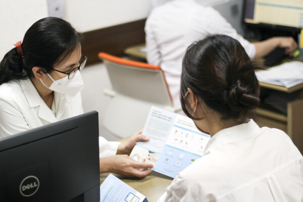 베트남 하노이의대병원에서 의료진이 KT의 비대면 케어 서비스 앱 ‘닥터어라운드’ 사용법을 환자들에게 설명하고 있다./ 사진=KT