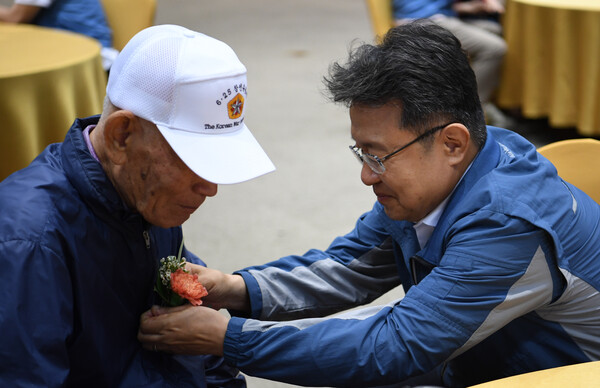 한성희 포스코이앤씨 사장이 6.25 참전 어른신에게 꽃을 달아 드리고 있다. /사진 = 포스코이앤씨.