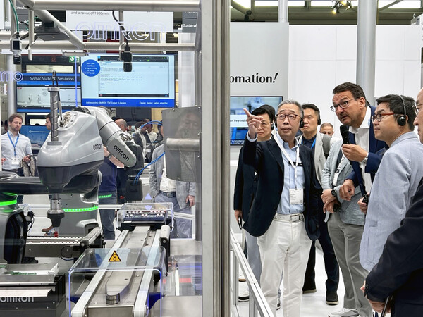 ‘오토매티카 2023’을 참관한 박지원 두산그룹 부회장(왼쪽)이 한 로봇업체 부스에서 회사 관계자에게 제품에 대해 질문하고 있다. 사진=두산그룹