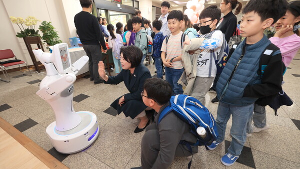 신계용 과천시장과 아이들이 시청 로비에서 AI 로봇을 체험하고 있다/사진=과천시